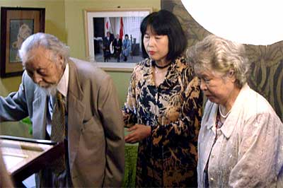 左から「名誉市民の証」を受ける鶴巻三郎さん、娘の純子さん、妻のマサさん