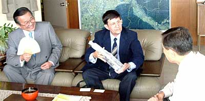 三条市長（右）にキューバのブランデーを手渡すアブレウ文化参事官（中央）