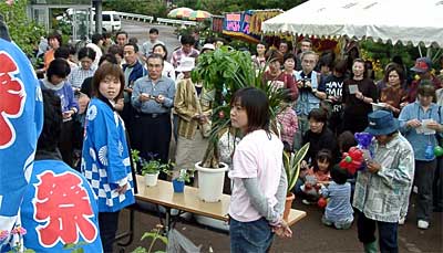 秋の保内公園まつりで真剣な表情でビンゴ大会に参加する来場者