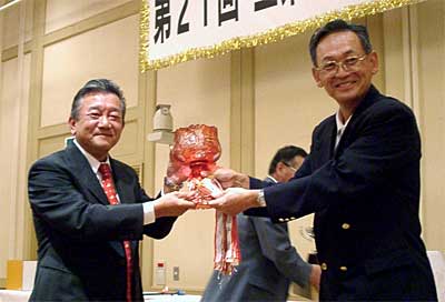 第21回会頭杯ゴルフ大会で渡辺会頭(右)からクリスタルの会頭杯を受け取る岡田久徳さん(左)