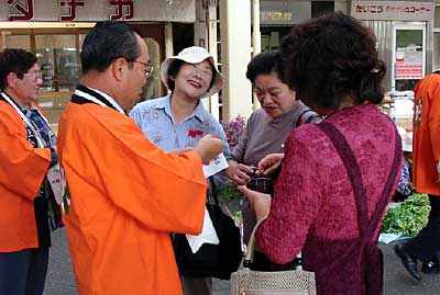赤い羽根の街頭募金で主婦に囲まれる高橋燕市長