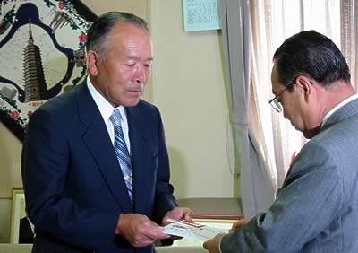 燕製品青空即売会実行委員会と(株)エムテートリマツからの寄付を高橋燕市長に手渡す鳥部社長(左)