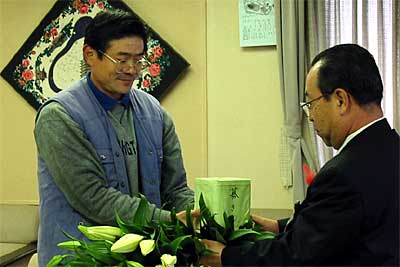 高橋燕市長に募金箱ごと善意を手渡す熊倉睦さん（左）