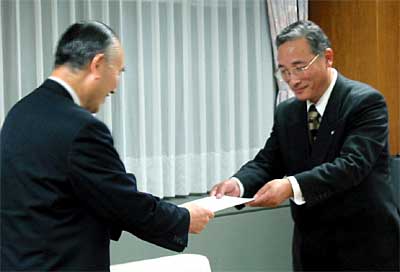 小池清彦加茂市長(左)に抗議文を手渡す佐藤邦義田上町長