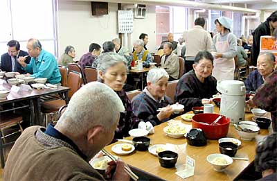 角利産業が寄付したモチで一足早く正月気分を味わう県央寮に入所するお年寄り