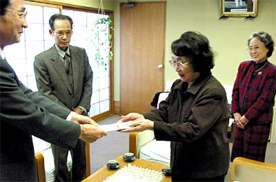 穂苅日本画研究会から燕市への寄付を柄沢英子さんが石本昌昭収入役に手渡す