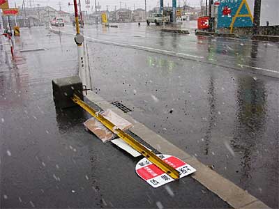 強風で倒れた上保内踏切停留所の看板、昼ころに三条市上保内地内の国道403号線