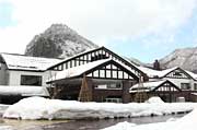 雪化粧した八木ヶ鼻を背にする「いい湯らてい」