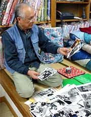 秋山さんを撮影した写真を広げる捧さん