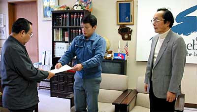 高橋燕市長(左)に要望書を手渡す「合併問題を考える会」の宮路代表(中央)、首藤会員(右)