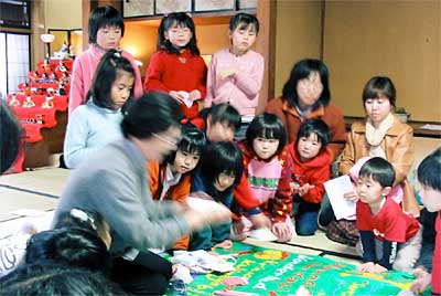 三条市丸井今井邸の「わくわくこどもおはなし会」で折り紙のひな人形を教わる子どもたち