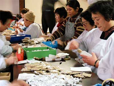 鮮やかな手さばきで福豆を袋詰めする本成寺婦人会会員