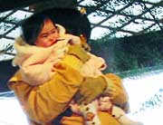 鬼に抱かれて顔をしかめる子ども