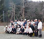 シダレザクラを背景に記念撮影するメンバー