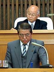 大山議長(後)の前で大山議長の不信任決議の理由を説明する大岩市議(前)