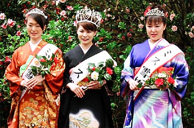 満開のユキツバキを背に左からミス雪椿の高野さん、ミス雪椿クイーンの五十嵐さん、ミス雪椿の阿部さん