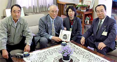 自費出版の写真集『かやぶきと生きる』51冊を燕市に寄付した捧武さん(左から2人目)