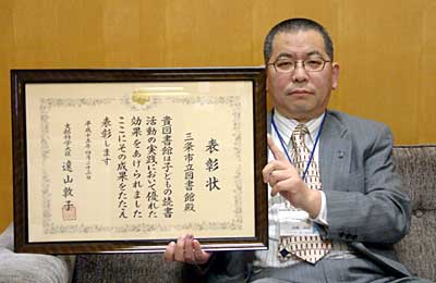 文部科学大臣名の表彰状を手に羽賀吉昭三条市立図書館長