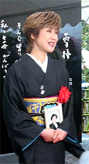 母の遺影を胸に話す小林さん