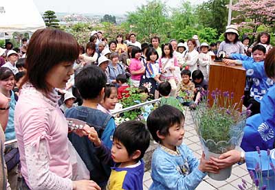 春の保内公園まつりのビンゴ大会で花鉢を受け取る