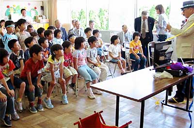 「北のなかまの会」の開所式で登石教育長のマジックに見入る子どもたち