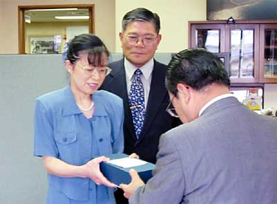 左から寄付を手渡す湯川秀美さん、湯川舘野区長、高橋燕市長