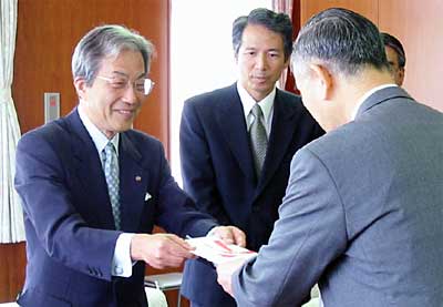 小池清彦加茂市長（背中）に目録を手渡す高橋作衛協栄信用組合理事長（いちばん左）