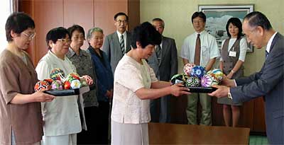小池加茂市長に手作りの手まりを手渡す加茂手まりの会会員