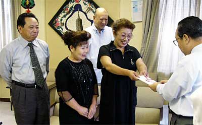 高橋燕市長に善意を手渡す-燕はぐるま座燕公演実行委員会の委員