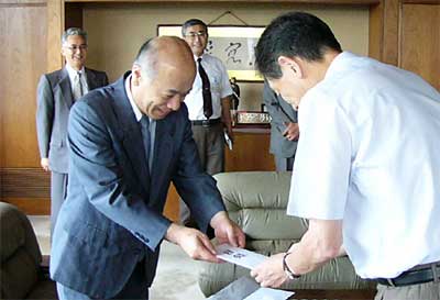 高橋市長（右）に目録を手渡す内田(株)コロナ社長（左）
