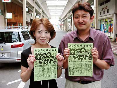商店街で200mいちびのちらしを手にする実行委員会のメンバー