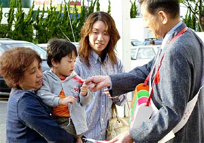 6日行われたジャスコ三条店での赤い羽根の街頭募金で赤い羽根を手渡す高橋三条市長