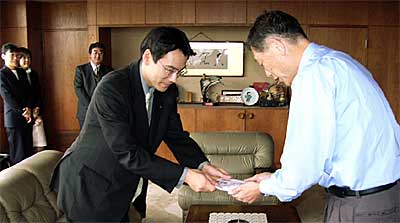 高橋三条市長(右)に善意を手渡す岡村所長(右から2番目)
