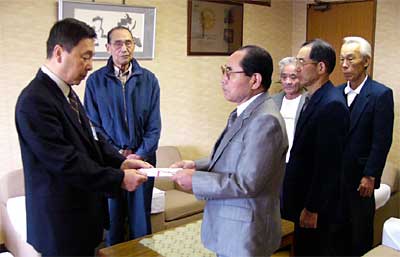 中野助役（いちばん左）に善意を手渡す小松チャリティパーティー実行委員長（左から3人目）はじめ燕社交ダンス踏友会会員