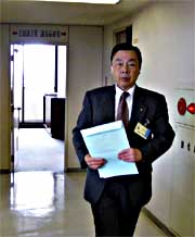 硬い表情で議長室を出る中野助役