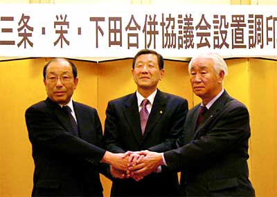 調印後、がっちり握手する左から小林栄町長、高橋三条市長、佐藤下田村長