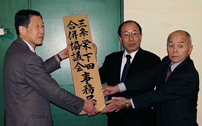 事務局に三条・栄・下田合併協議会の看板を掲げる左から高橋三条市長、小林栄町長、西川下田村助役