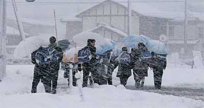 三条市保内で吹雪の中を学校から帰る中学生