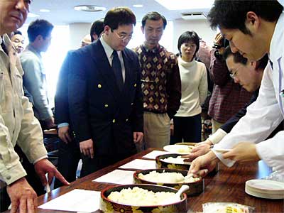 (社)県央研究所の古米の付加価値化に関する研究の発表報告会でみその上澄み水で炊いたコメを試食する参加者