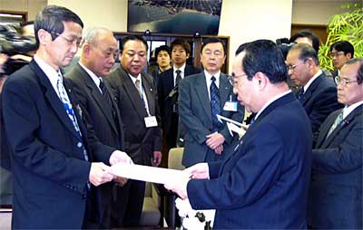 高橋燕市長(右)に合併協議会への参加を求める文書を手渡す高橋寺泊町長(左)