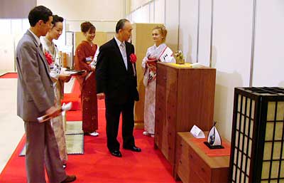 16日まで開かれている2004加茂桐たんす見本市の会場で説明を受ける小池加茂市長