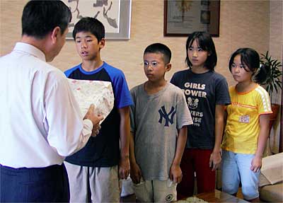 中野助役に募金箱を手渡す燕西小学校ボランティア委員会の児童