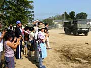 自衛隊の車両を拍手で見送る市民