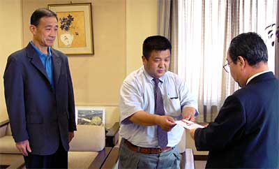 左から中之口ライオンズクラブの峯島幹事、池田会長、そして義援金を受け取る高橋市長
