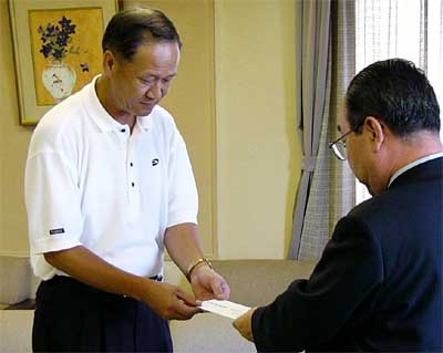 高橋燕市長(左)に義援金を手渡す佐々木エポンゴルフ取締役店長