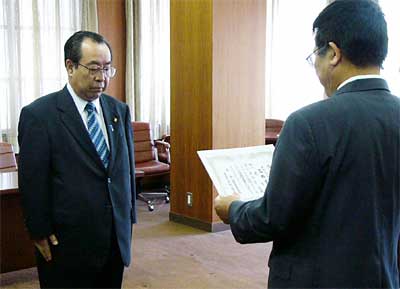 星野燕市選管委員長(右)から直立不動で当選証書を受ける市長選4選を果たした高橋氏