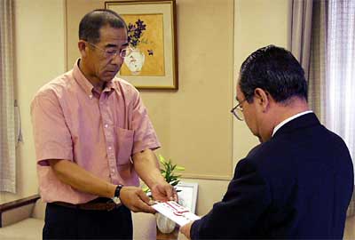 高橋燕市長(右)へ三条市7・13水害義援金30万円を手渡す柳原柳原組専務(左)