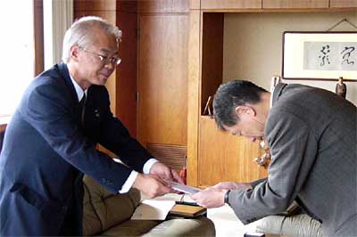 高橋三条市長(右)に街路灯30灯の目録を手渡す佐藤東北電力(株)三条営業所所長(左)