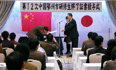 4日の第12回中国鄂州市研修生終了証書授与式と研修生送別会で終了証書を受ける研修生