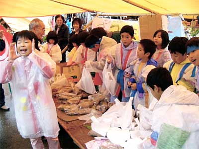 三条市の二七の定期市に出店してサツマイモを売る下田村立飯田小学校3年生